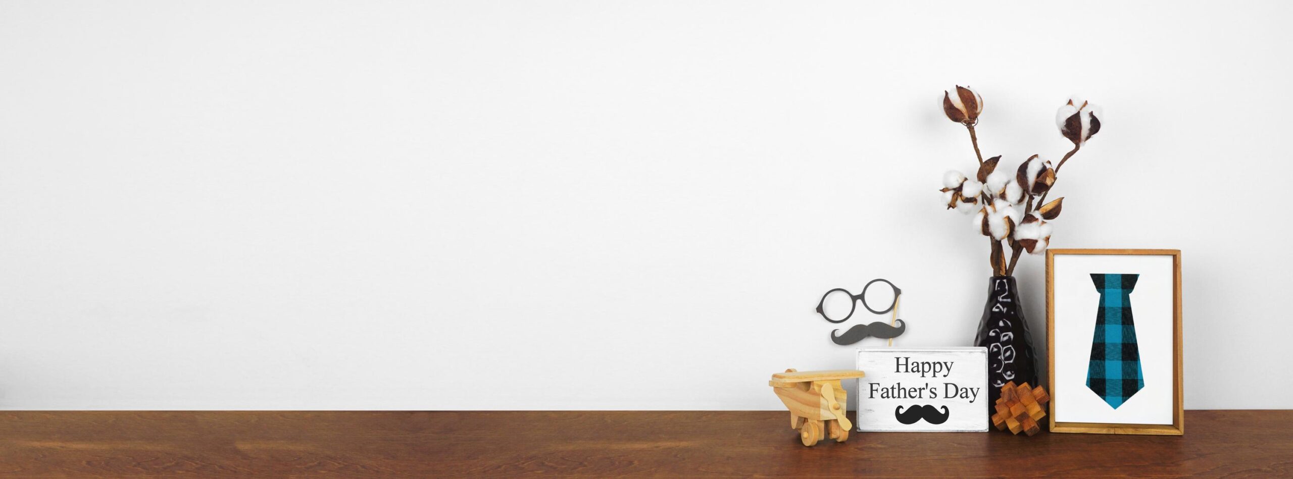 Fathers Day decor with rustic wood signs and branches on a wood shelf against a white wall banner
