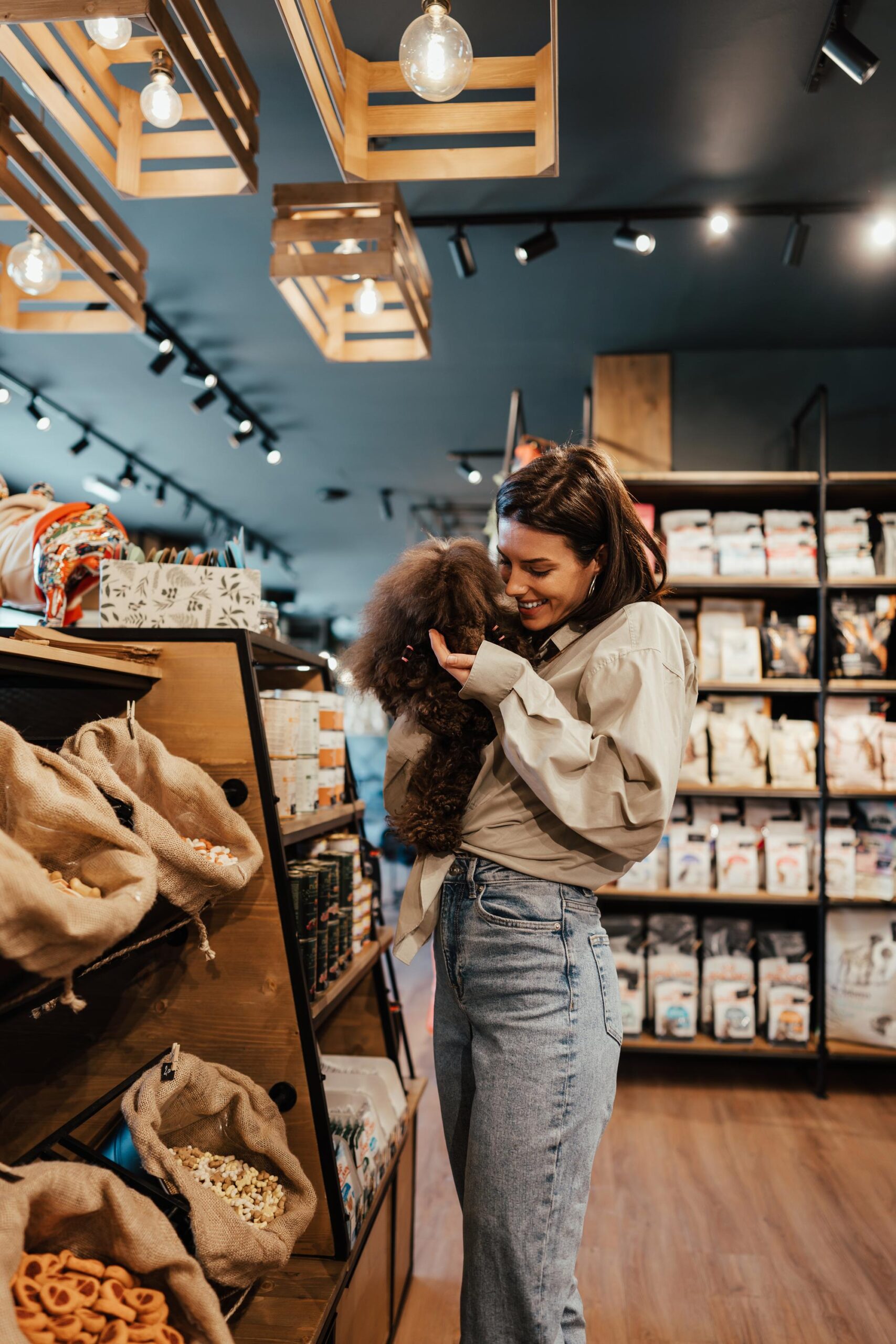 Young woman with poodle in pet shop